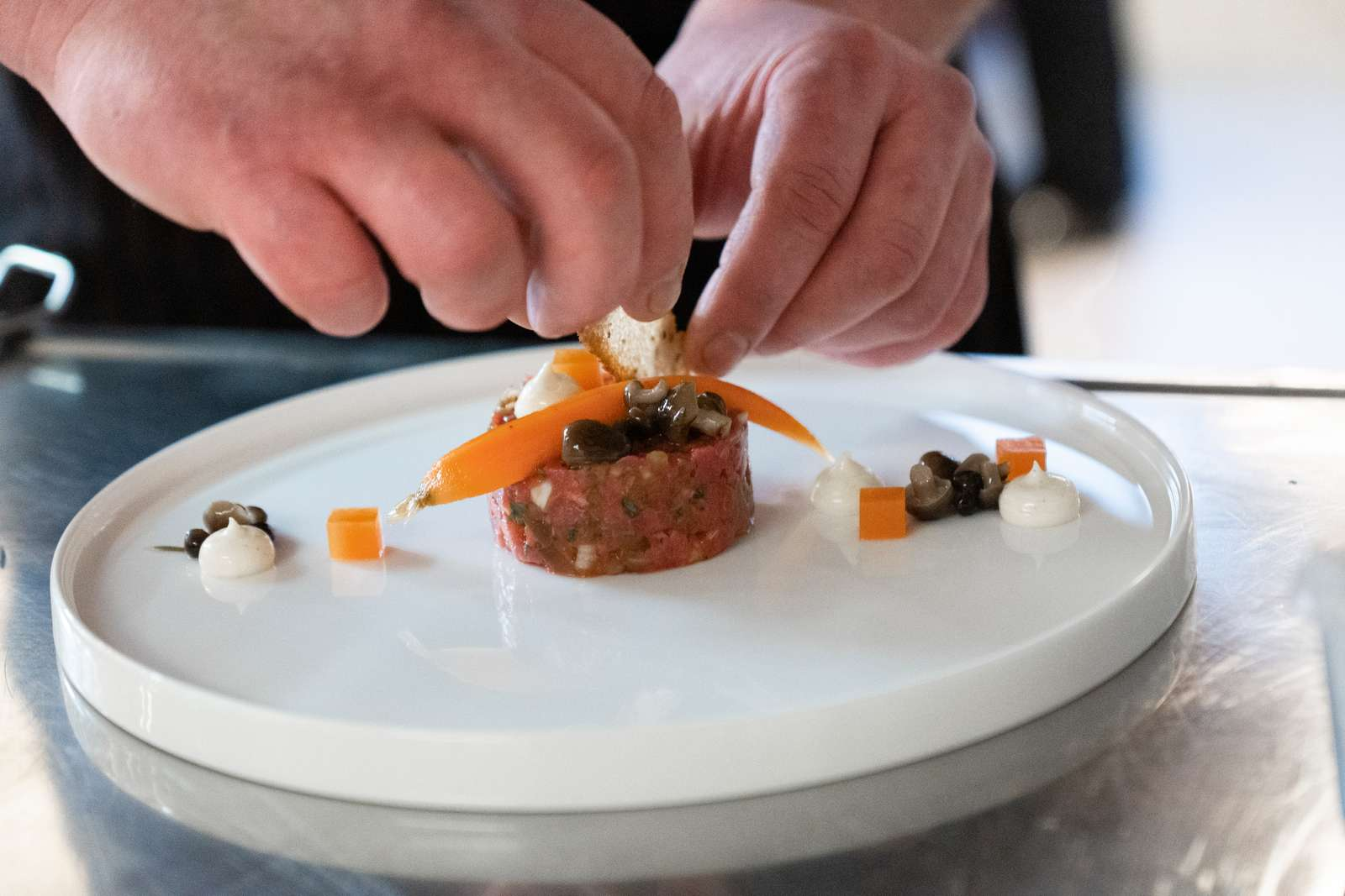 A dish is arranged in the center of a plate in a modern way